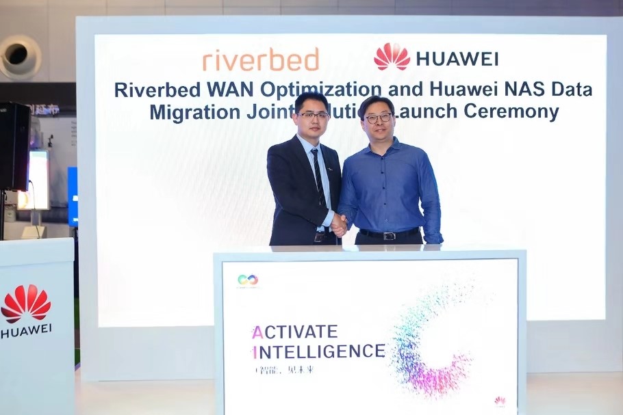 Executives from Riverbed Technology and Huawei shake hands as they jointly release a WAN solution at HUAWEI CONNECT 2018