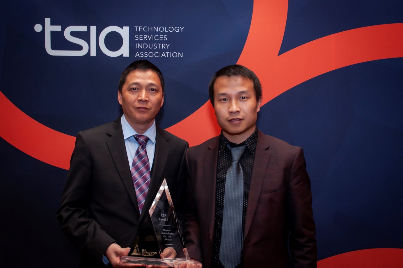 Li Xiaoming and Ren Yuanzhuo of Huawei Enterprise Mexico GSC holding a Support Staff Excellence award from TSIA