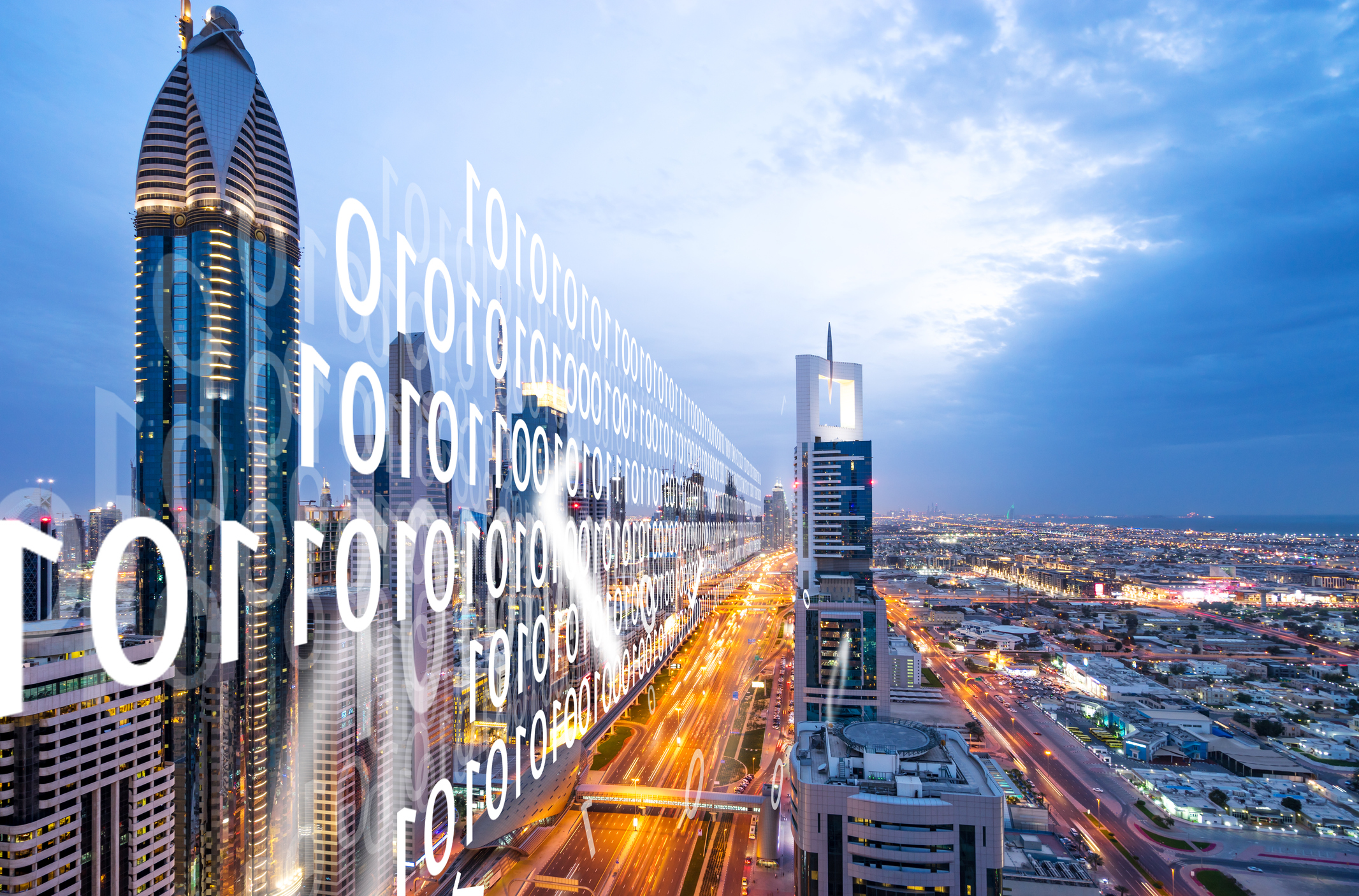 Looking along the tops of skyscrapers lining a city thoroughfare lit up at dusk, with binary code representing digital power