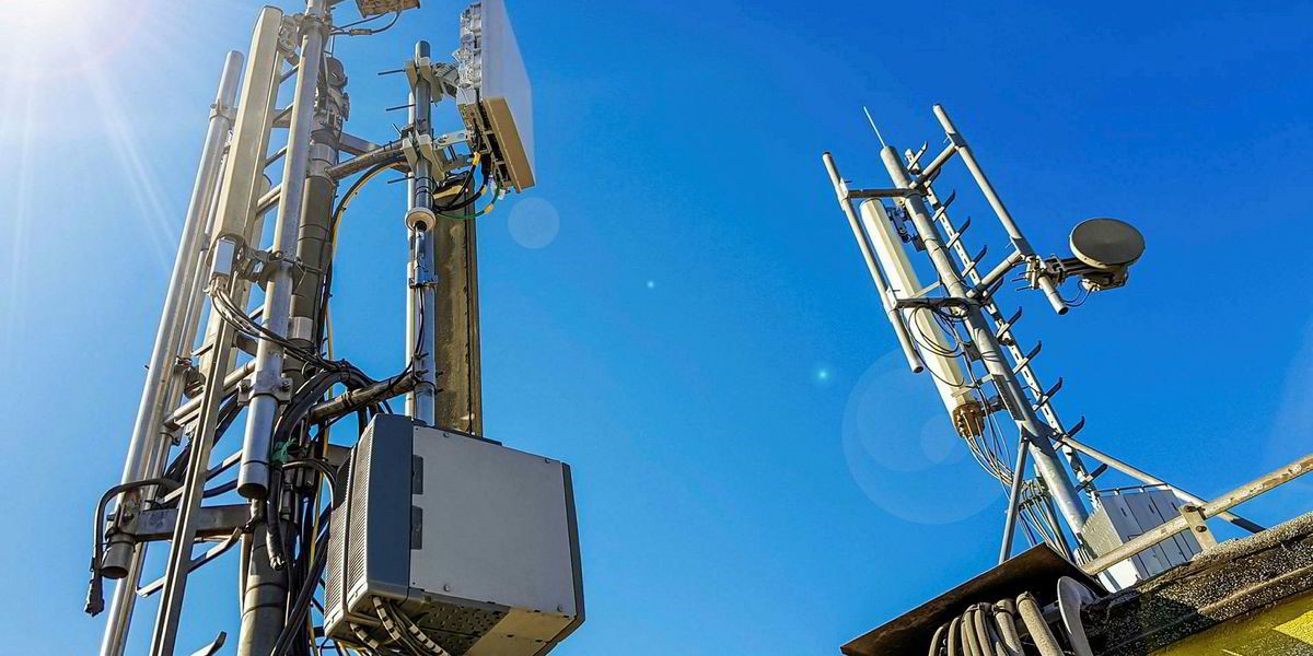 A 5G base station set against a blazing blue sky, illustrative of digital transformation in the oil and gas sector with 5G