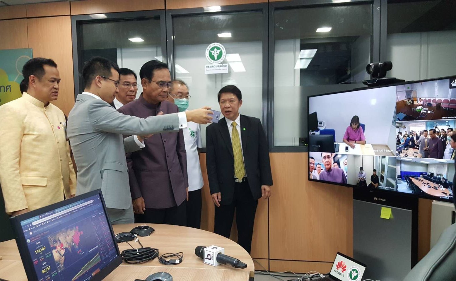 Thai officials and Huawei representatives in front of a Telemedicine Video Conference Solution, donated to combat COVID-19