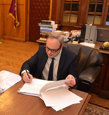 Prof. Anastas Gerdjikov, Rector of Sofia University St. Kliment Ohridski, seated at a desk signing an MoU with Huawei