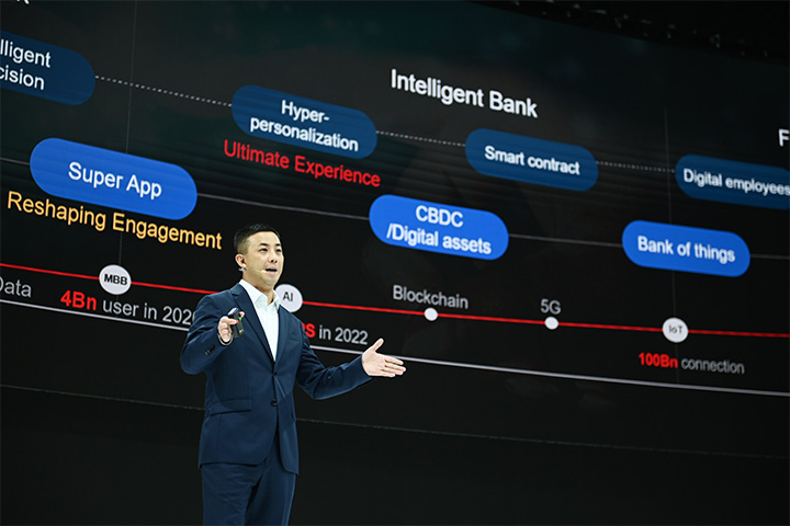Jason Cao, CEO globalnych finansów cyfrowych Huawei, wygłasza przemówienie na Huawei Intelligent Finance Summit 2022, ekran za nim pokazuje schemat ilustrujący inteligentny bank
