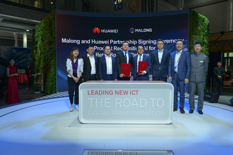 Executives from Huawei and Malong Technologies pose on a podium to mark the signing of a cooperation agreement