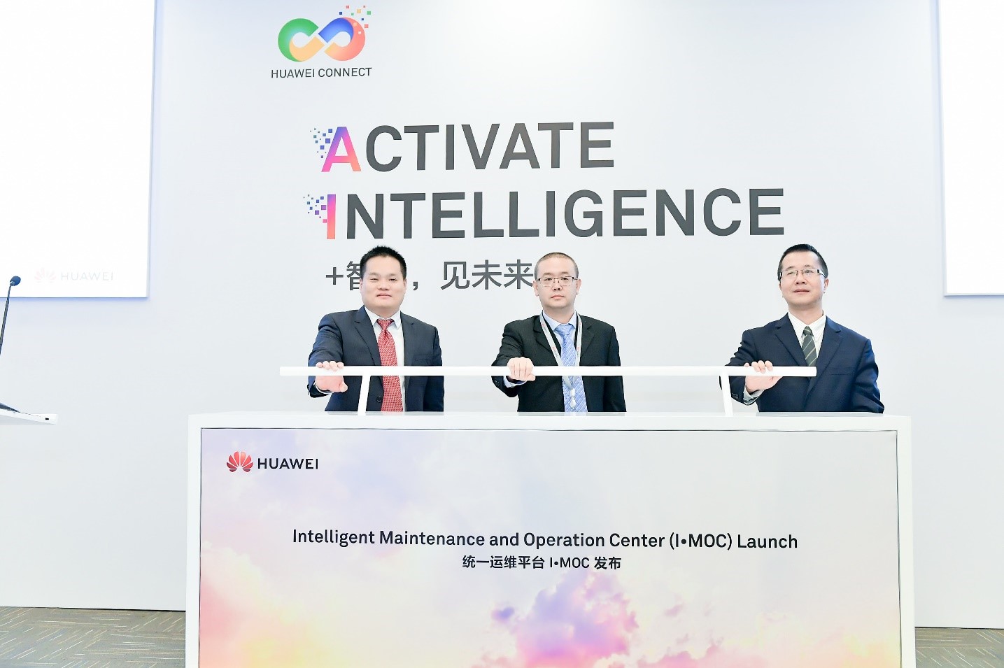 Huawei executives standing behind a desk at the launch of the Intelligent Management and Operation Center (IMOC) platform