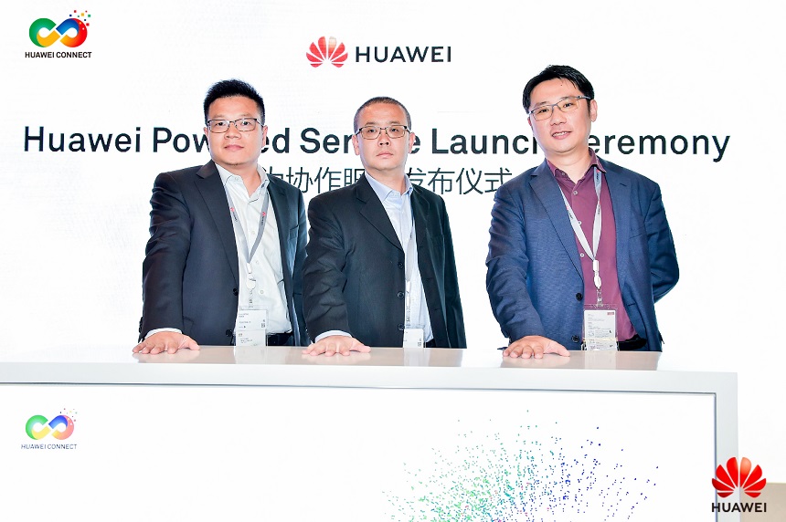 Huawei Enterprise's Ye Zhonghua, Liu Jianbo, and Hua Shuang standing behind a desk at the launch of Huawei Powered Service