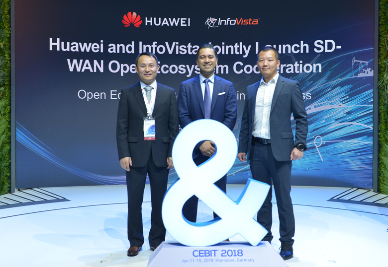 Huawei executives Wang Shaosen and Yang Te, and InfoVista's Faiq Khan, pose on stage to represent open cooperation in SD-WAN