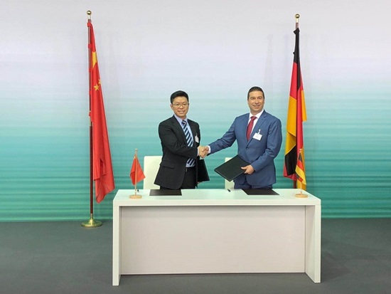 Saad Metz, EVP of Audi China, and Veni Shone, President of LTE Solutions at Huawei, shake hands at the signing of an MoU